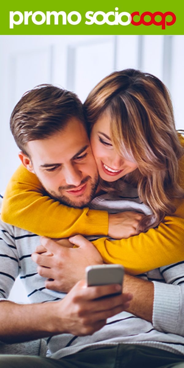 Ragazze che sorridono bevendo un caffè e guardando lo smartphone